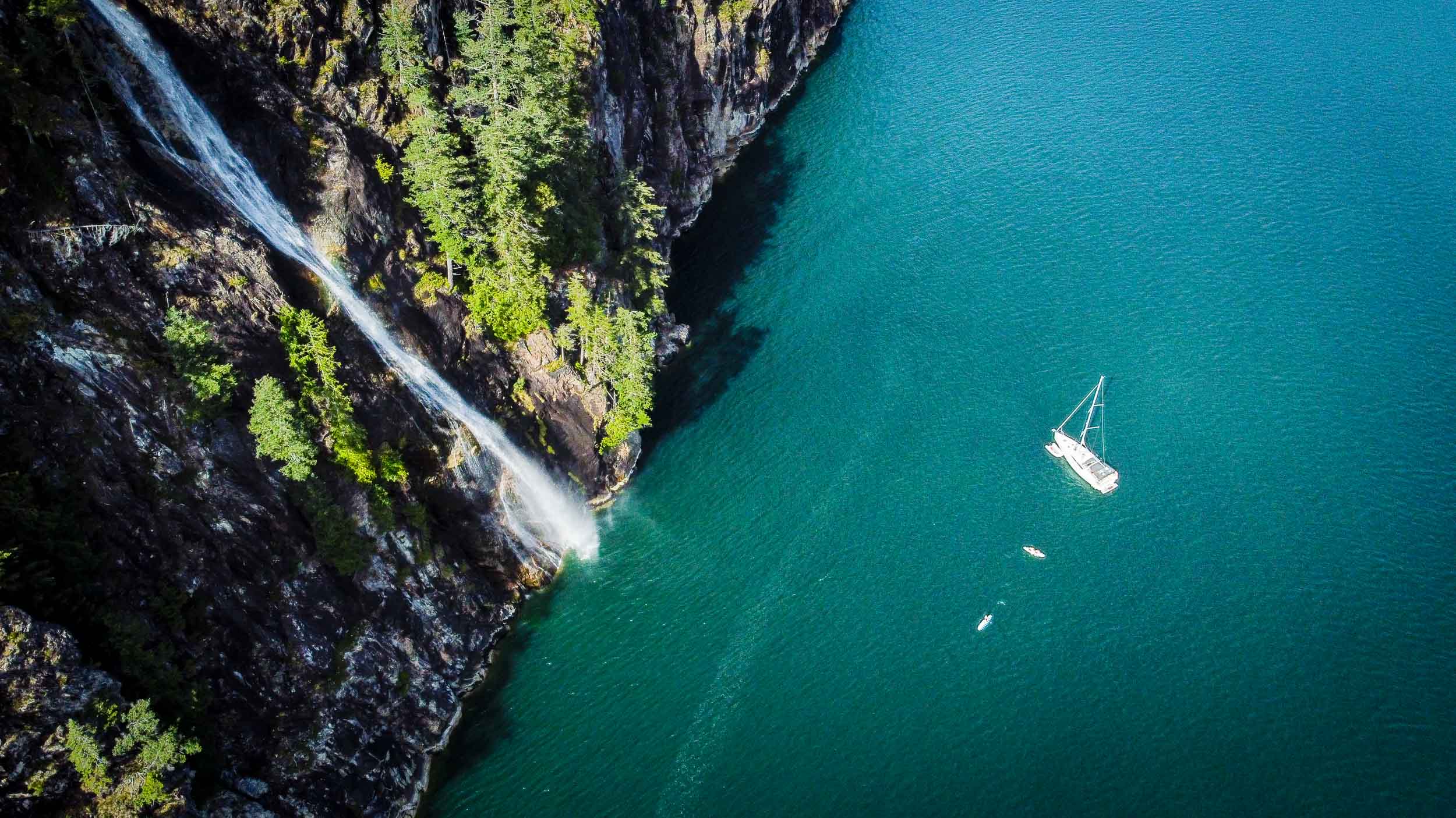 Aerial view of rocky Howe Sound coastline and clear water.